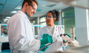 Two R&D scientists from a CRO talking while in a lab.